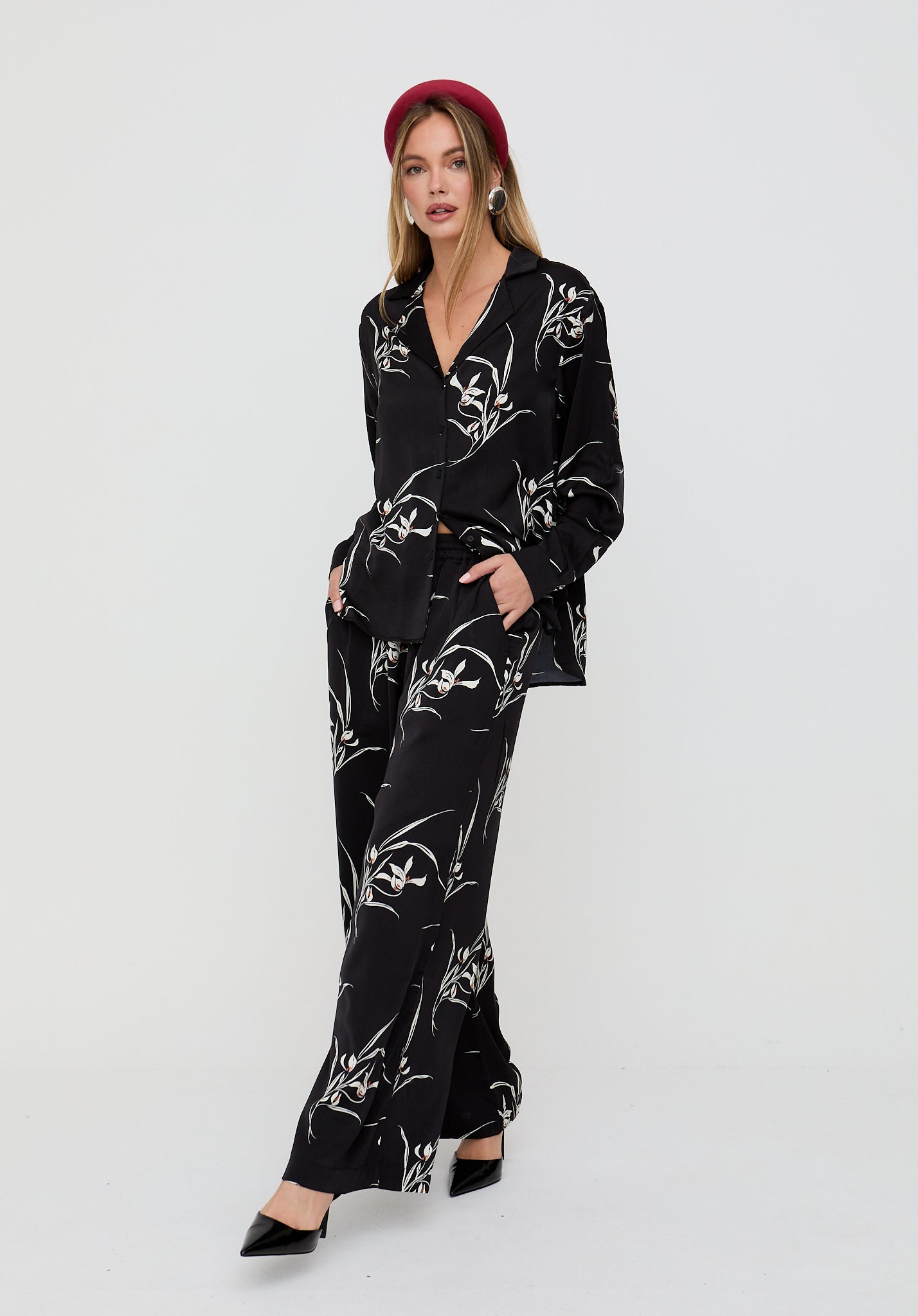 Woman wearing a black floral patterned outfit on a white background