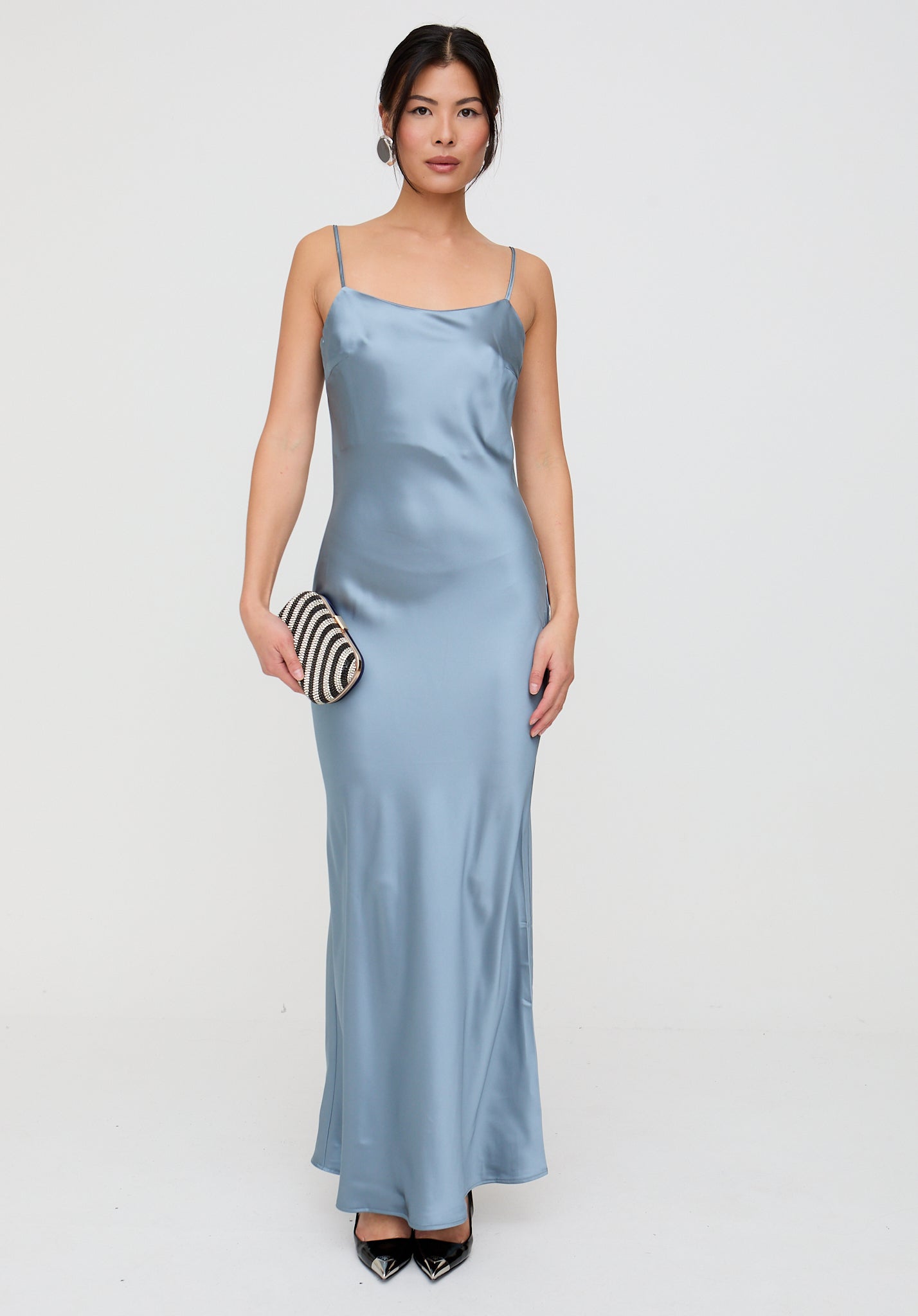 Woman wearing a light blue satin dress on a white background