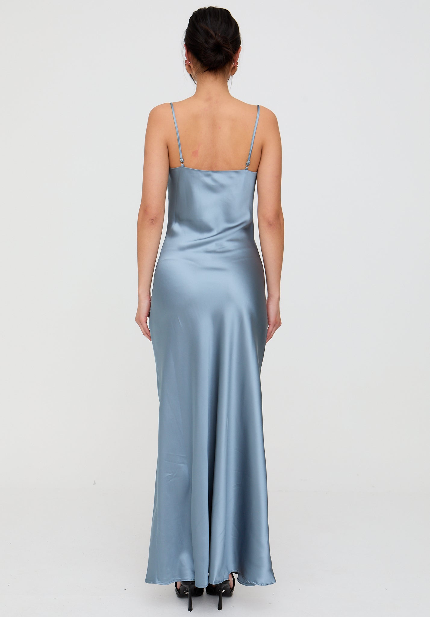 Woman wearing a light blue satin dress on a white background