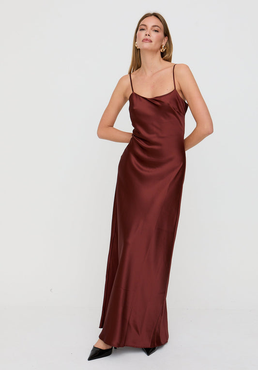 Woman wearing a burgundy satin dress on a white background