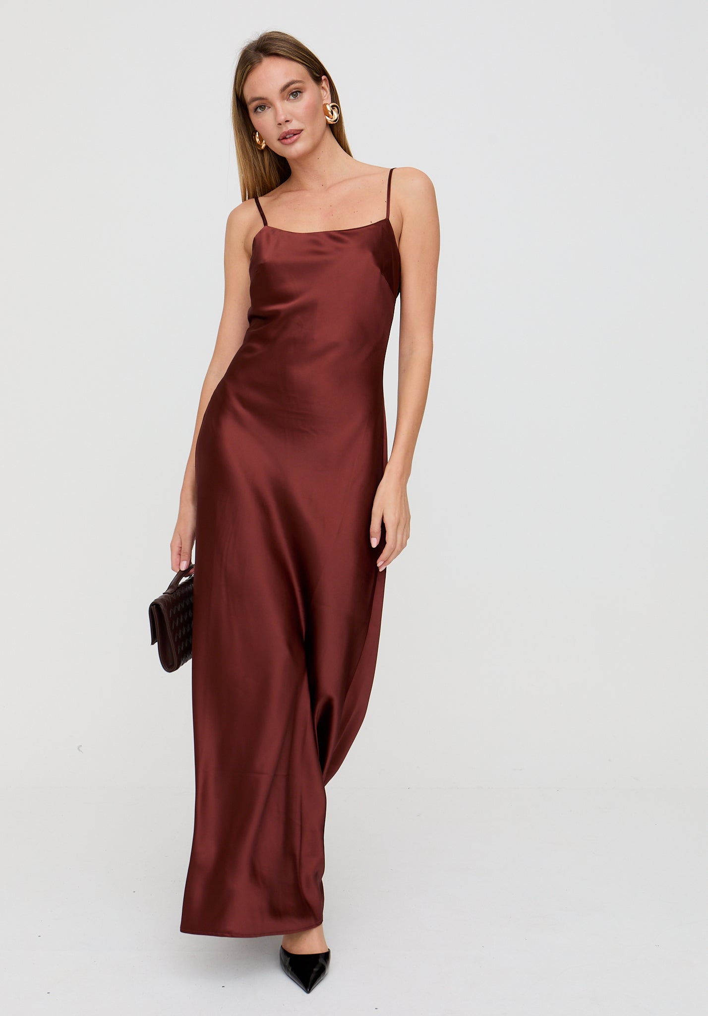 Woman wearing a burgundy satin dress on a white background