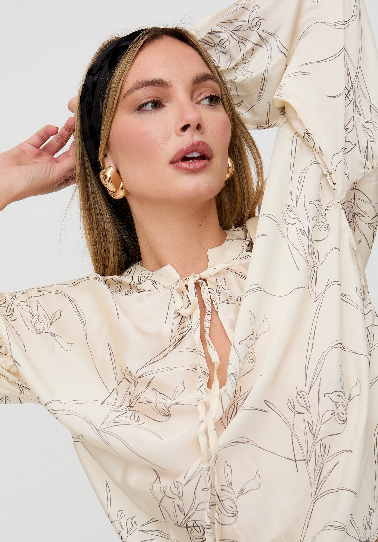 Woman wearing a floral blouse with a neutral background