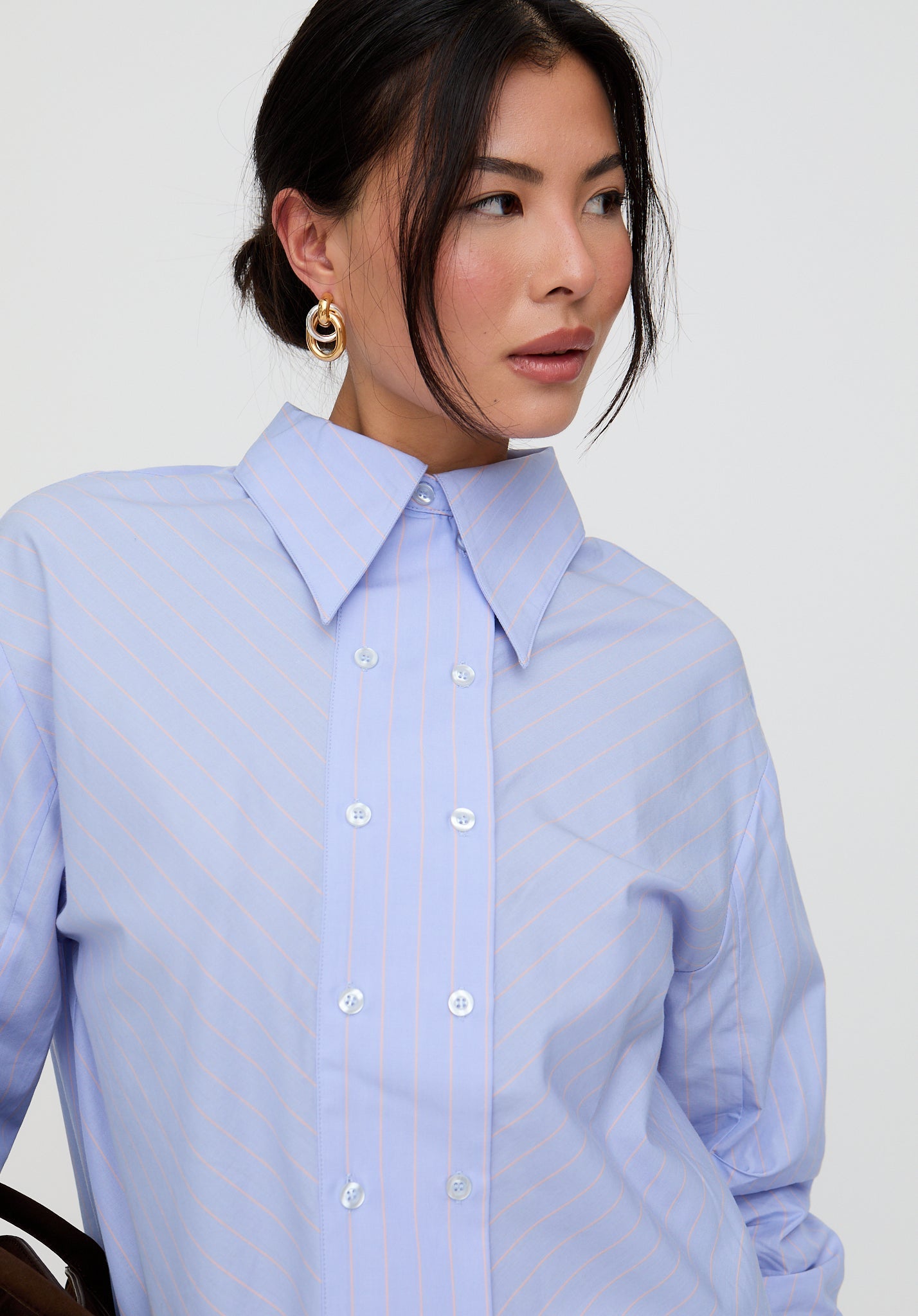 Woman wearing a light blue shirt against a plain background