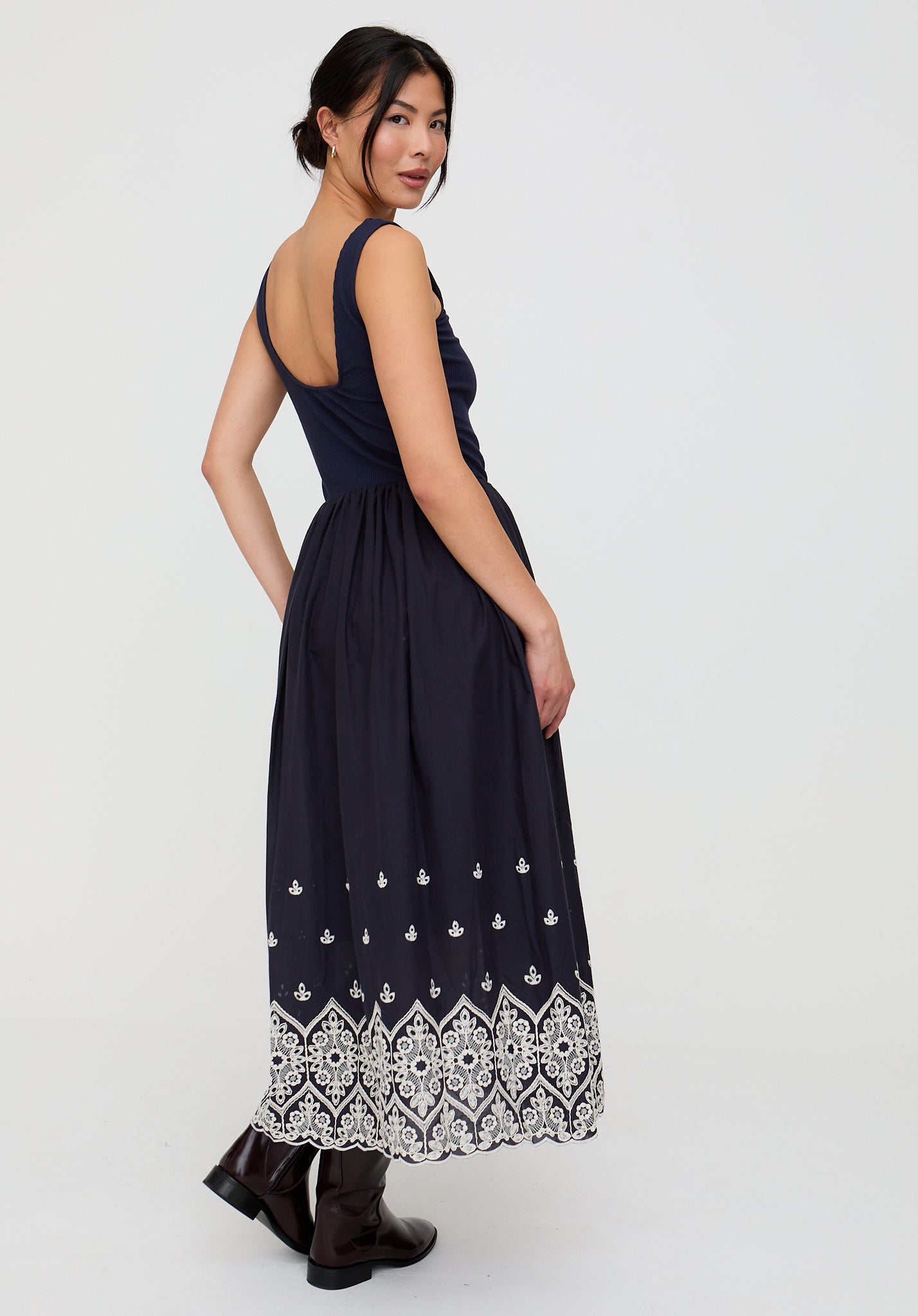 Woman wearing a black dress with white patterns on a white background