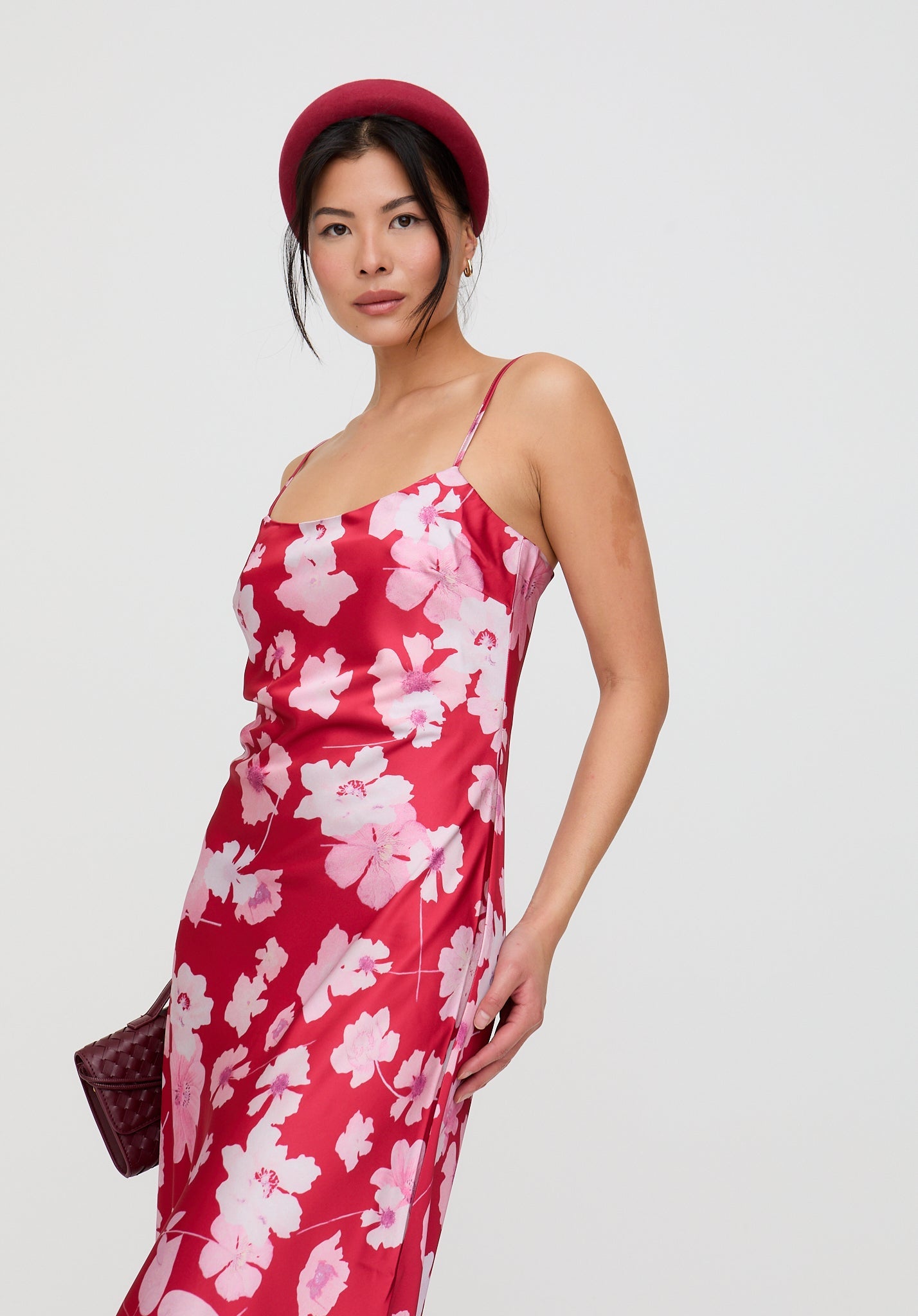 Woman wearing a red floral dress with a plain background