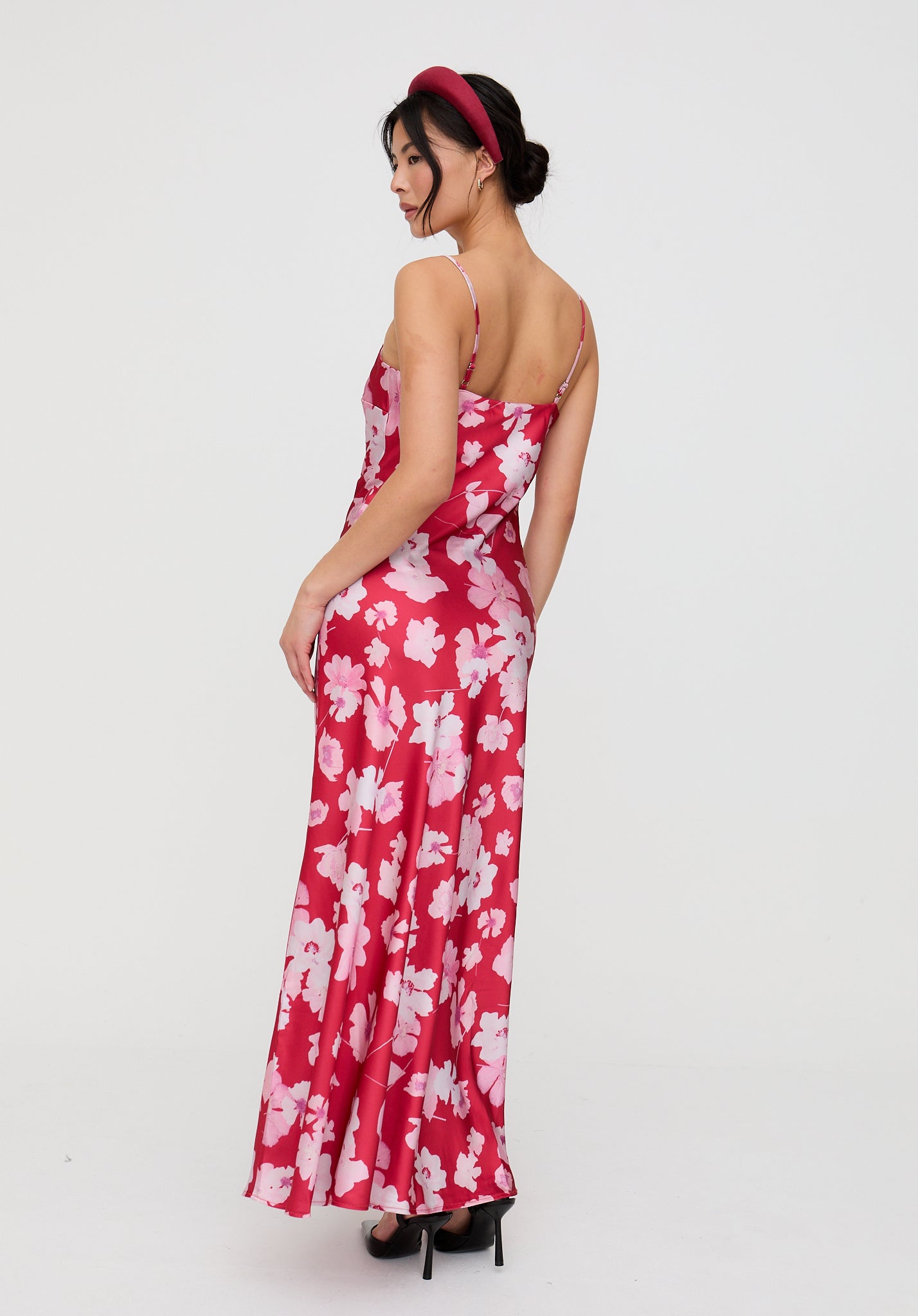 Woman wearing a red floral dress on a white background