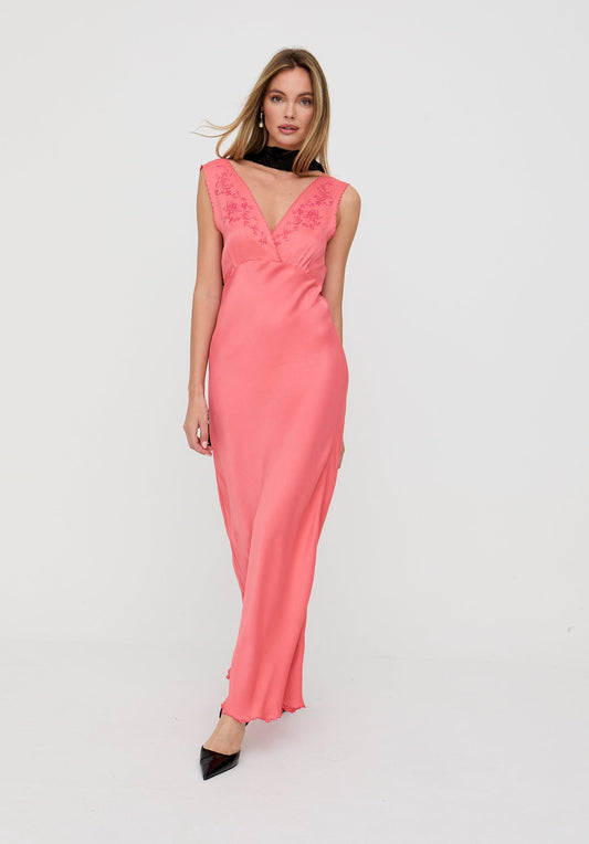 Woman wearing a pink dress with lace details on a white background