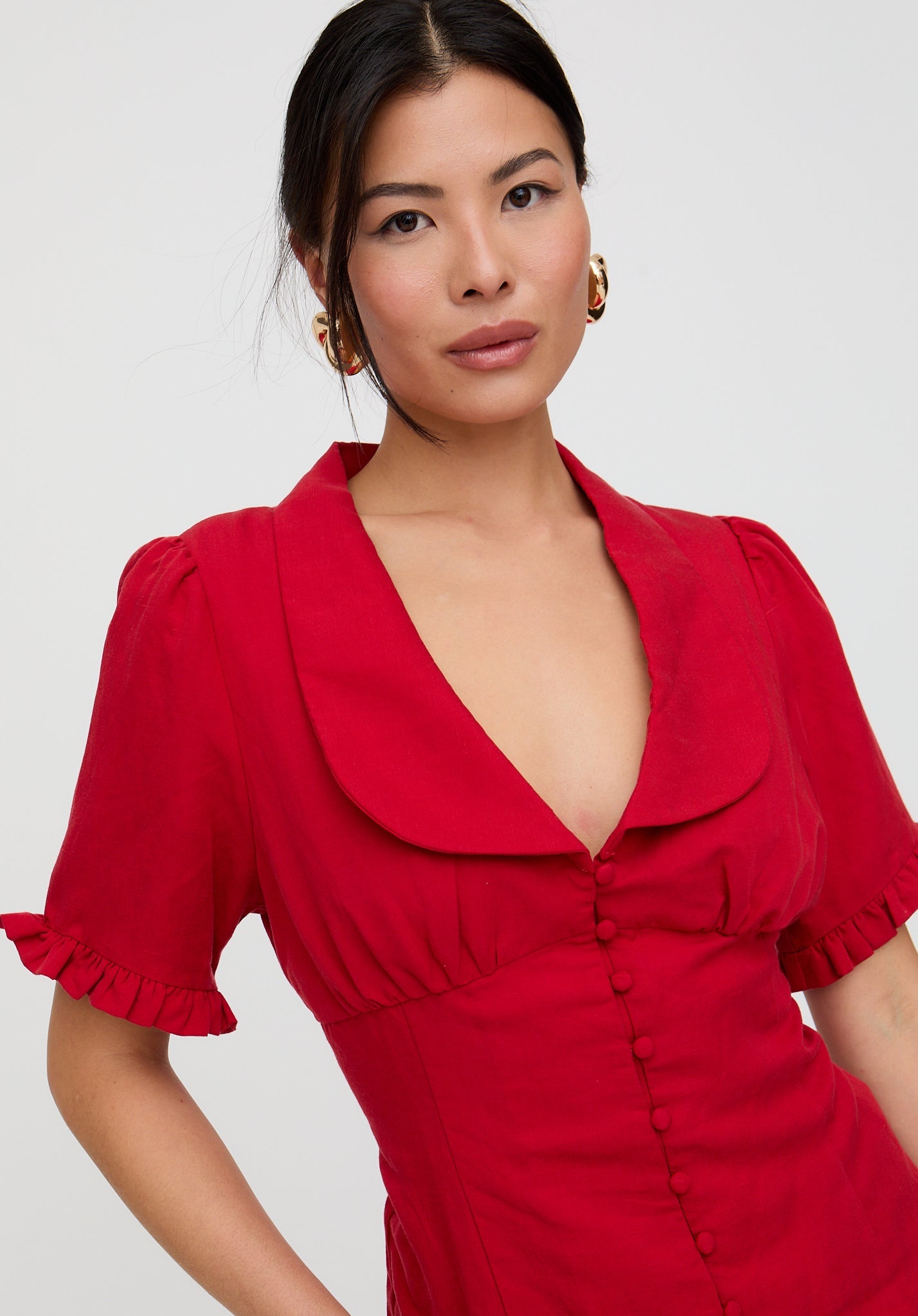 Woman wearing a red dress with a plain background