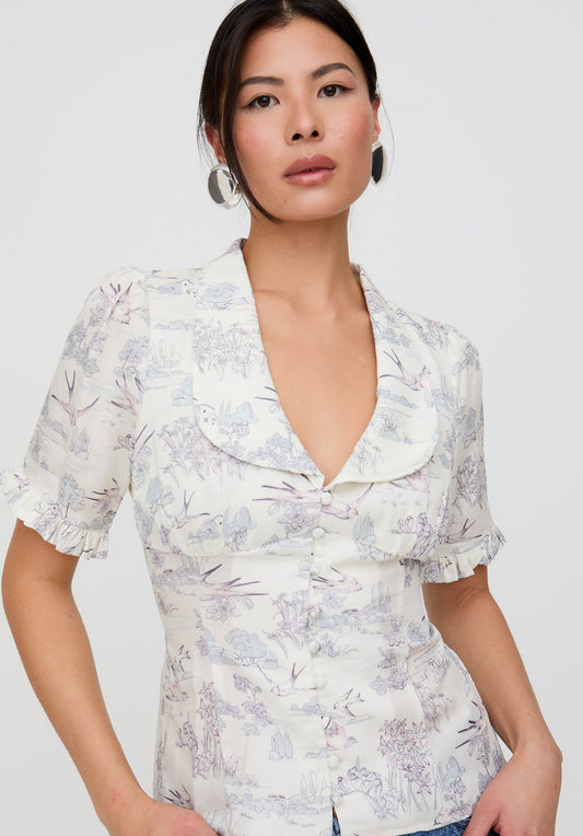 Woman wearing a floral blouse with a plain background